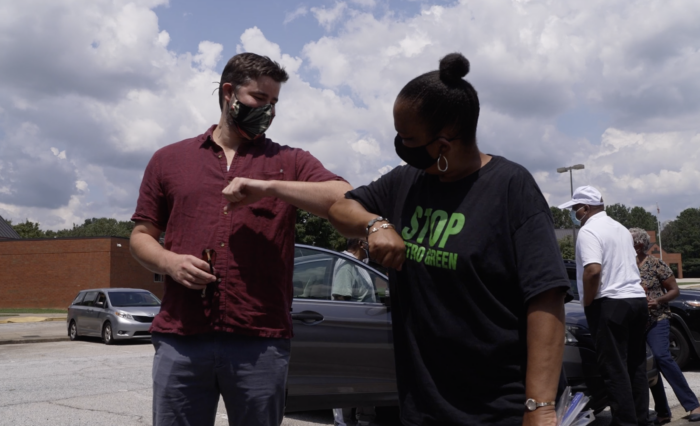 SELC Attorney Bob Sherrier bumps elbows with CHASE President Renee Cail during a car protest.